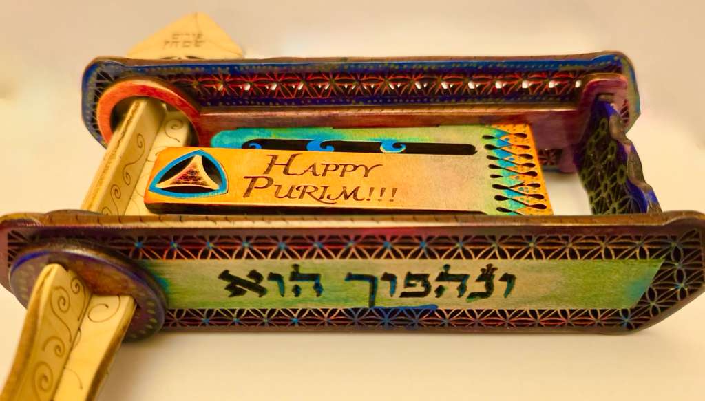 Hand-painted gragger in blues, greens, purples and golds with ונהפוך הוא handle